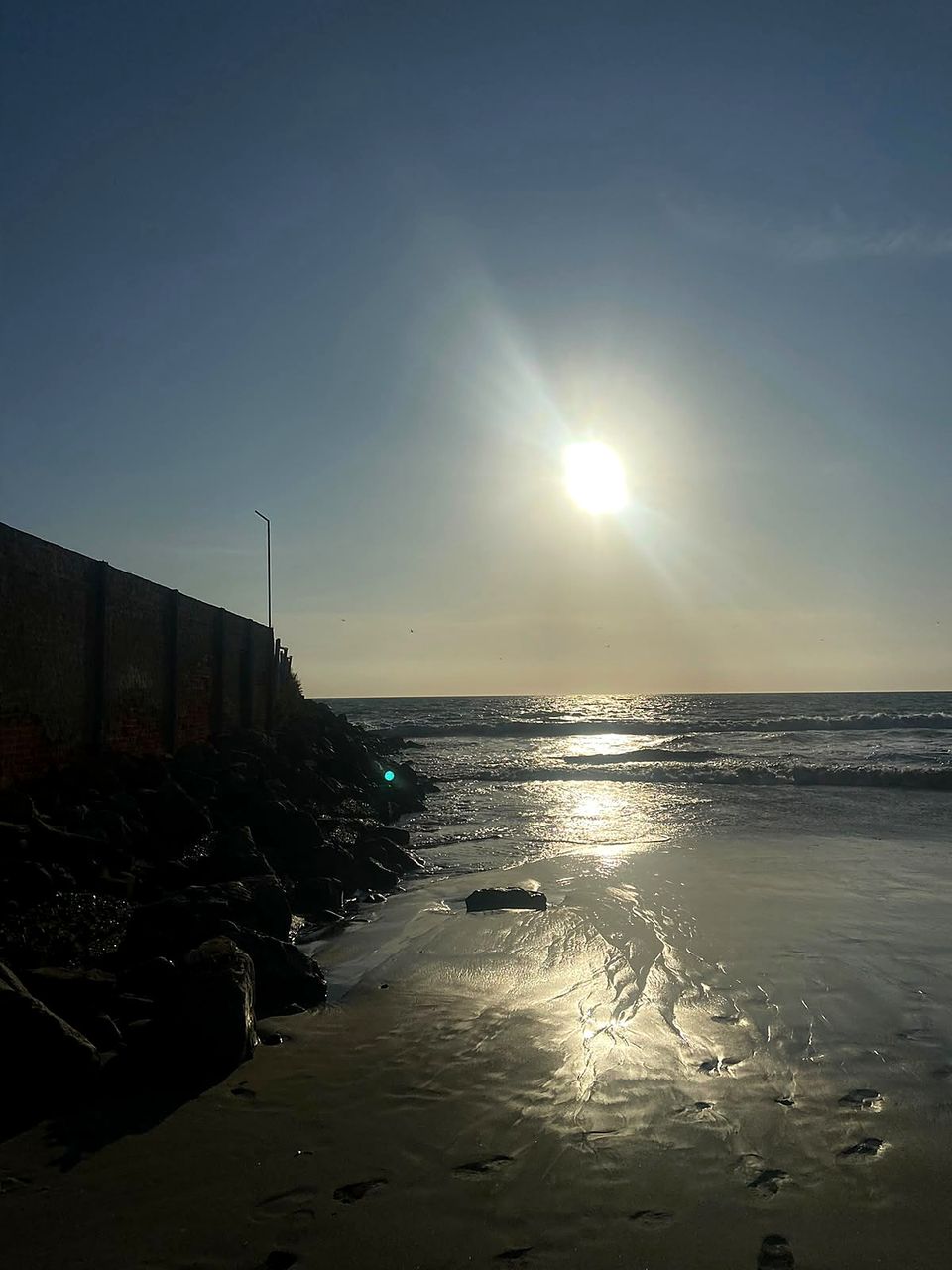 El sol de la tarde reflejado en la arena mojada