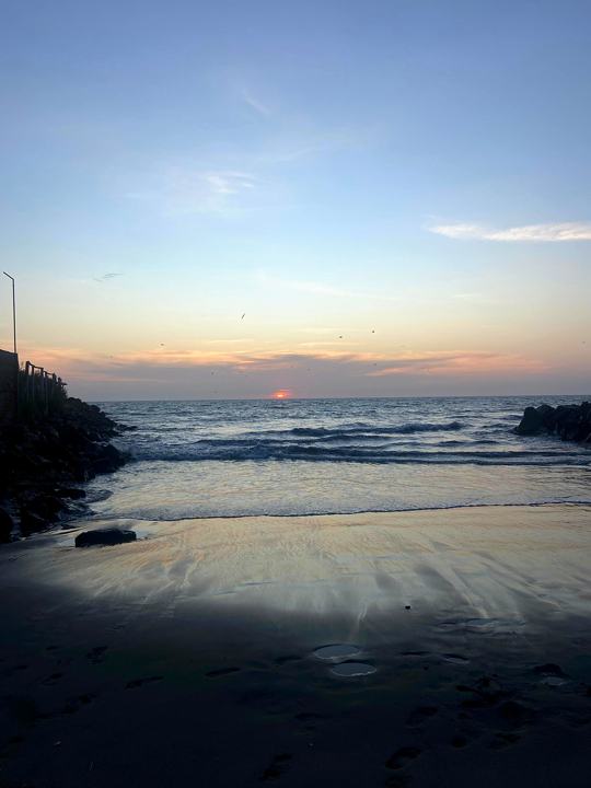 Atardecer en la orilla de Colán, entre dos espigones de rocas