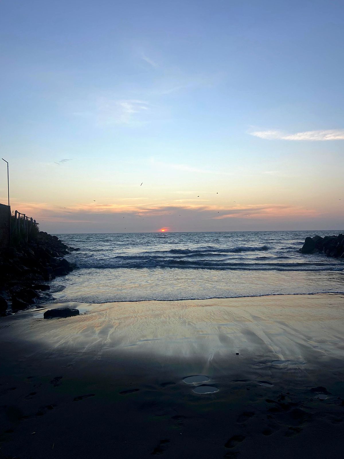 Atardecer en la orilla de Colán, entre dos espigones de rocas